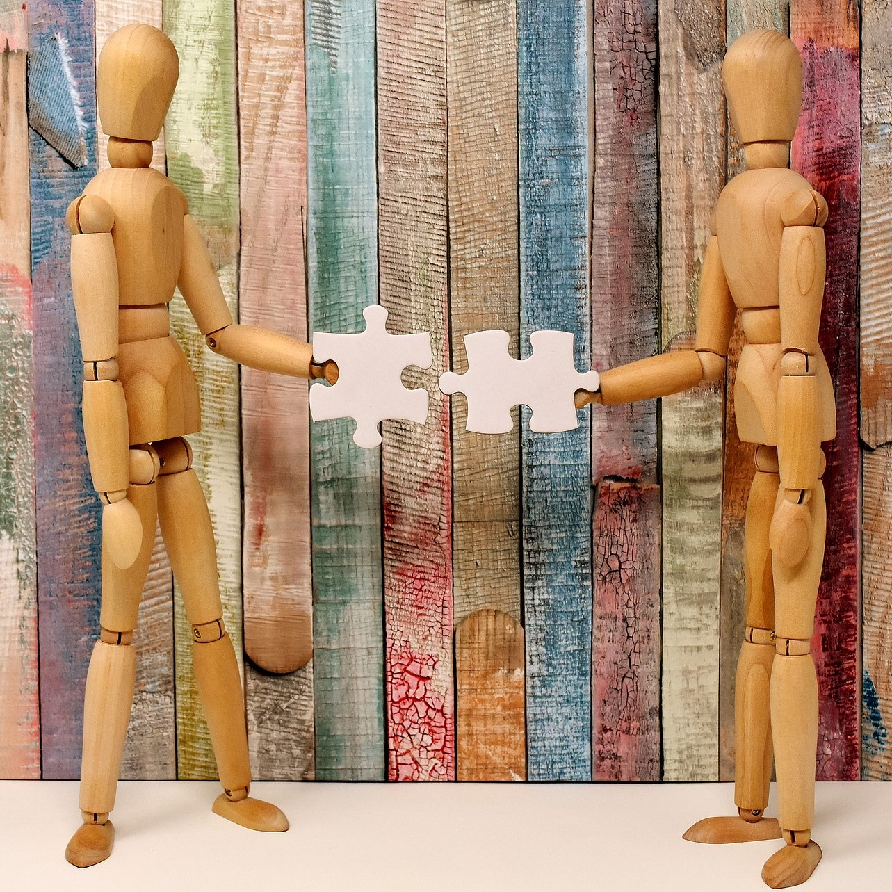 Illustration de deux personnages prêts à assembler les pièces d'un puzzle